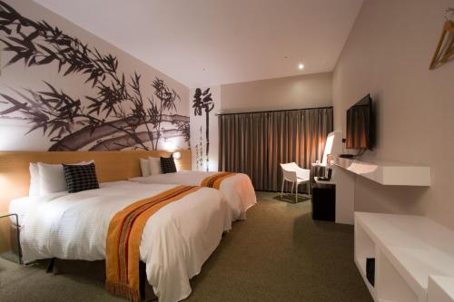 una camera d'albergo con un grande letto e una TV di Travel Art Inn a Città di Chiayi