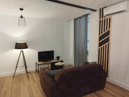 un salon avec un canapé et une télévision dans l'établissement Cosy studio rénové style industriel, à La Seyne-sur-Mer