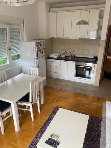 una cucina con un tavolo e un frigorifero bianco di Zara Apartman a Herceg-Novi