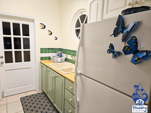 a kitchen with butterflies on the side of a refrigerator at 21 Plantations Paradise in Lowlands