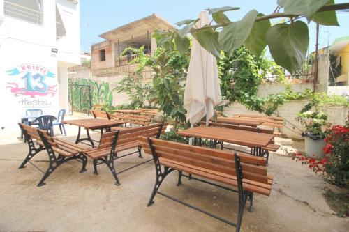 a group of benches and tables with an umbrella at Hostel K13 in Sarandë