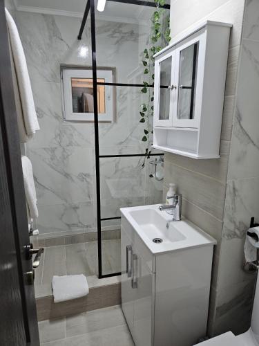 a white bathroom with a sink and a mirror at Zet Studio in Brăila