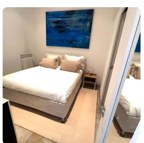 une chambre avec un lit et un tableau au mur dans l'établissement 2 pièces mezzanine et grande terrasse très calme 30 secondes de monaco, à Beausoleil
