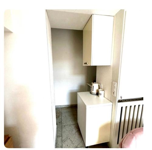 Elle comprend une petite cuisine équipée d'un réfrigérateur blanc et de placards. dans l'établissement 2 pièces mezzanine et grande terrasse très calme 30 secondes de monaco, à Beausoleil