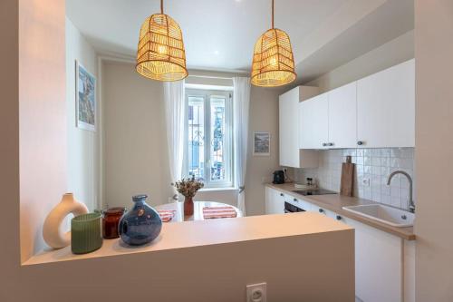 - une cuisine avec deux lampes suspendues et un comptoir dans l'établissement Studio - Calme - à 700m de la plage et calanques, à Marseille