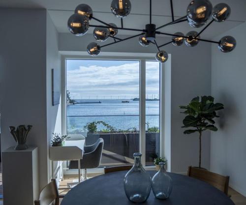 two glass vases on a table with a view of the ocean at Brand New & Full Sea View Apartment in Copenhagen in Copenhagen