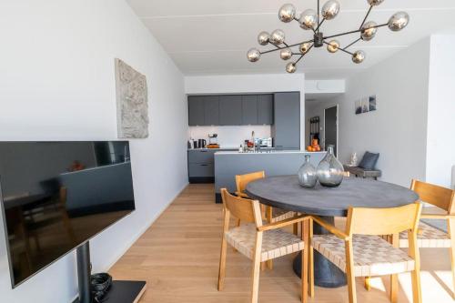 a dining room and kitchen with a table and chairs at Brand New & Full Sea View Apartment in Copenhagen in Copenhagen