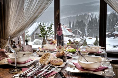 a table with plates of food and wine glasses at Winter & Summer Resort in Ždiar