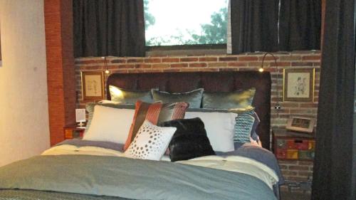 a bed with a bunch of pillows on it at The Nest in Ajijic
