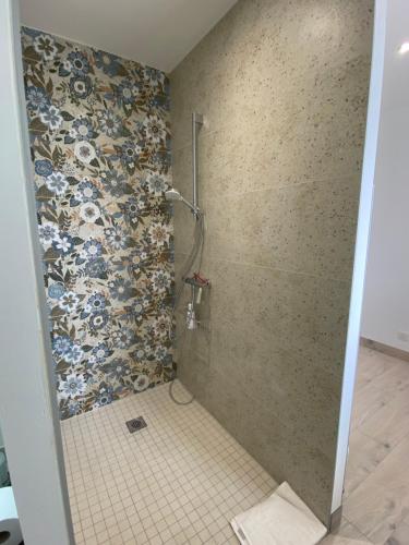 a bathroom with a shower with a mosaic wall at Les gîtes des Lauriers roses Chambre privée Île d Aix in Geay