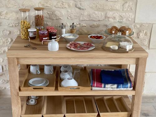 a wooden table with food on top of it at Les gîtes des Lauriers roses Chambre privée Île d Aix in Geay