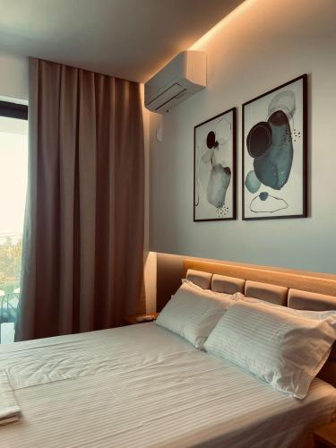a bedroom with a bed with two pictures on the wall at Villa27 Dhermi in Dhërmi