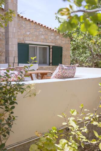 a balcony with a table and pillows on it at Oikia Ouranou in Khlóï