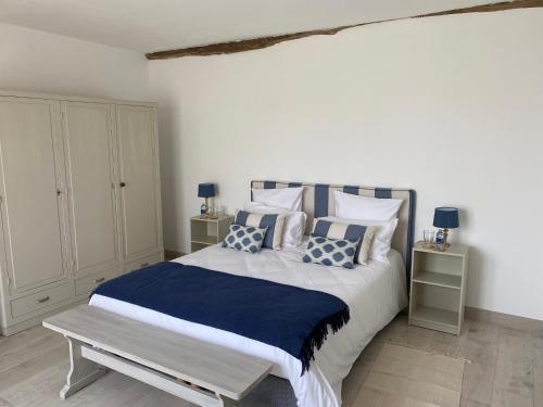 a bedroom with a large bed with blue and white pillows at Les gîtes des Lauriers roses Chambre privée Île d Aix in Geay