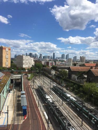 une vue sur une ville avec des trains à la gare dans l'établissement Superbe ROOF-TOP avec vue 360°, à Colombes