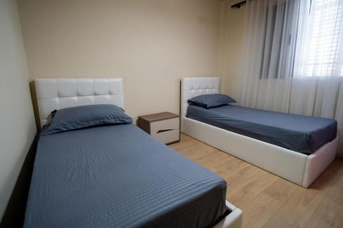 a bedroom with two beds and a window at Home in Shkoder with Outdoor Pool in Shkodër