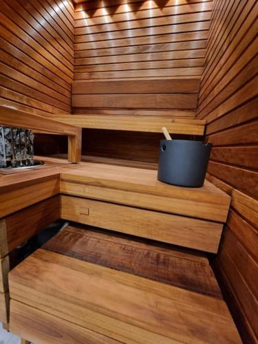 a wooden sauna with a bucket in the middle at Villa Haawe in Syöte