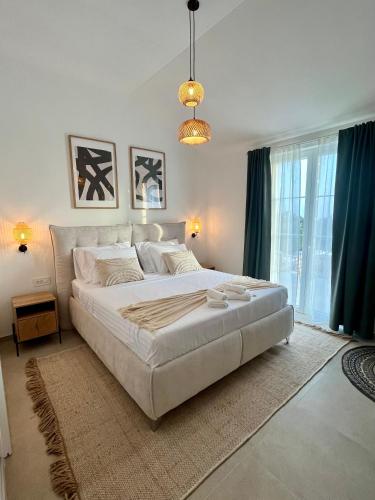 a large white bed in a room with a large window at Casa Katarina in Novalja