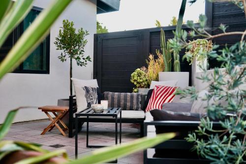 a patio with a couch and a table and plants at Newly Built, Bright, and Modern Guest Home in San Diego