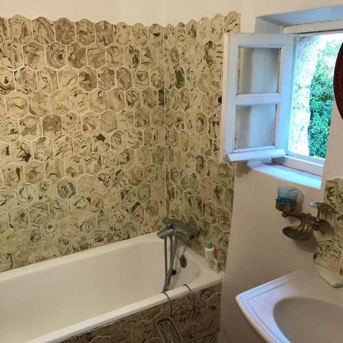 une salle de bain avec une baignoire et un lavabo dans l'établissement Le Baguier, maison de caractère dans hameau typique provençal, à Seillans