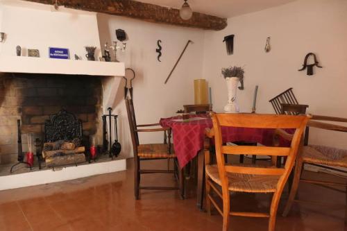 a dining room with a table and a fireplace at Le Baguier, maison de caractère dans hameau typique provençal in Seillans