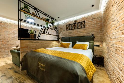 a bedroom with a bed and a brick wall at FREJA- Luxury Studio apartment Old town Zadar Center in Zadar