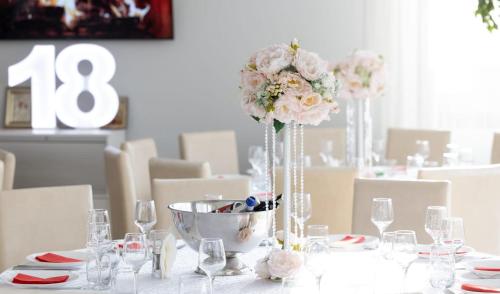 a white table with a vase of flowers on it at Mihai Palace in Buftea