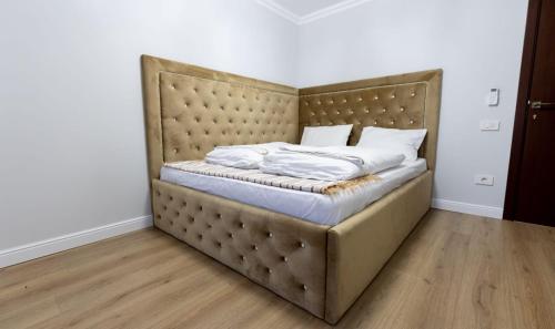 a bed with a large headboard in a room at Mihai Palace in Buftea