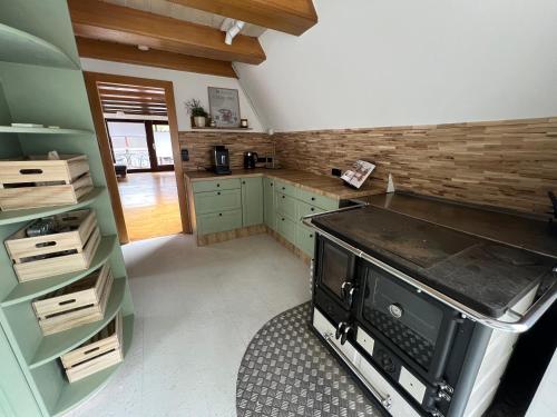 cocina grande con armarios verdes y fogones en Ferienhaus Teetied, en Südbrookmerland