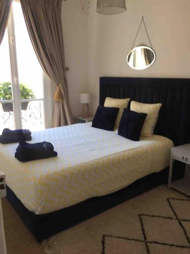 une chambre avec un grand lit avec des oreillers bleus dans l'établissement Côté Arc de Triomphe, à Paris