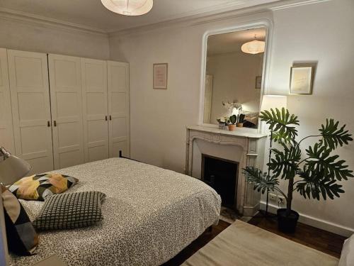 - une chambre avec un lit, une cheminée et un miroir dans l'établissement Charmant Nice appartement 5 personnes people max, à Paris
