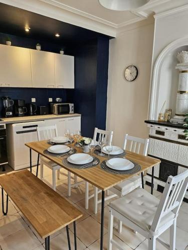 - une cuisine avec une table en bois et des chaises blanches dans l'établissement Charmant Nice appartement 5 personnes people max, à Paris