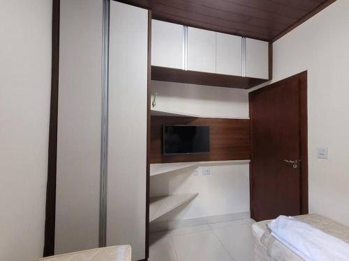 Zimmer mit einem Bett und einem Schrank mit einer Mikrowelle in der Unterkunft Casa do Cristiano no bairro Rosário in Ouro Preto