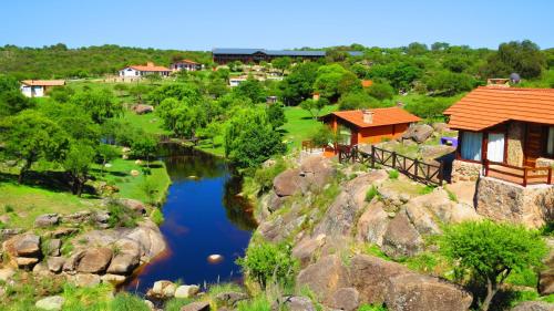 an overhead view of a river with a house at Los Ancares Resort in Mina Clavero