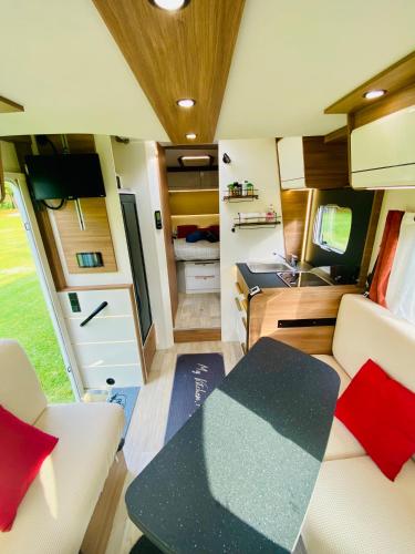 une caravane avec une table à manger et une cuisine dans l'établissement Logement insolite nature, à Varneil