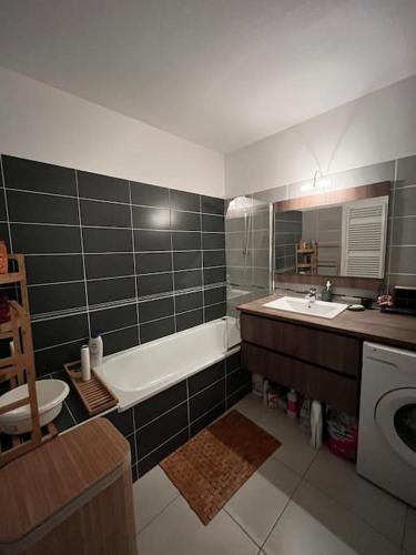une salle de bain avec une baignoire, un lavabo et des toilettes dans l'établissement Appartement entier, à Juvignac
