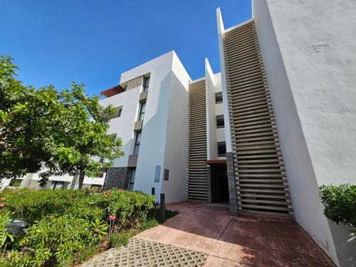 a white building with a staircase leading up to it at Appartement vue mer in Ajdir