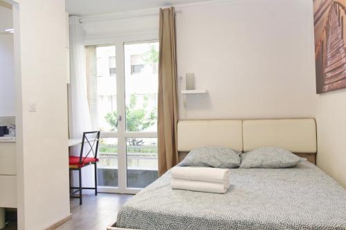 une chambre avec un lit avec une grande fenêtre dans l'établissement Cosy Thiers - Hypercentre - Wifi, à Avignon