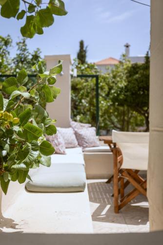 a row of pillows and a chair on a patio at Oikia Ouranou in Khlóï