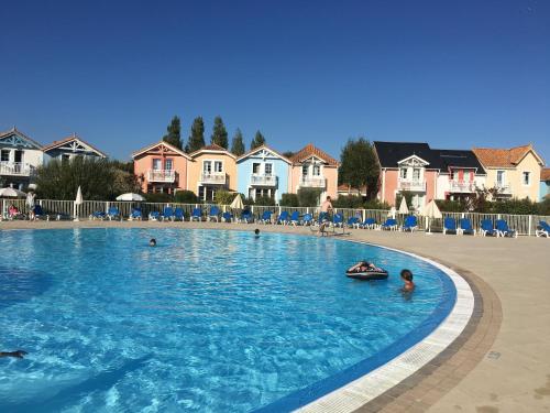 une grande piscine avec des gens dans l'eau dans l'établissement Maison calme sur golf, mer & campagne - Port Bourgenay, à Talmont-Saint-Hilaire