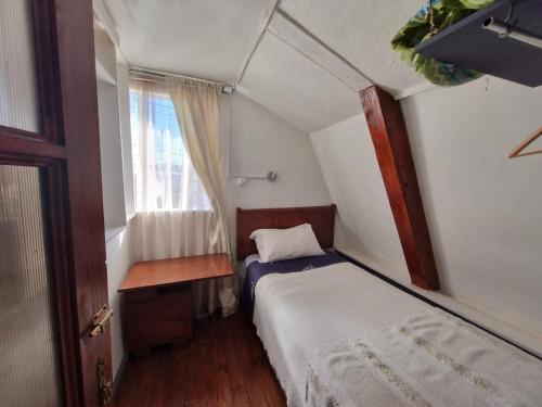 a small bedroom with a bed and a window at Casa Villa Amanecer in Villarrica