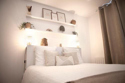 a bedroom with a white bed with white pillows at 2 Pièces Cosy - Mairie Des Lilas in Les Lilas
