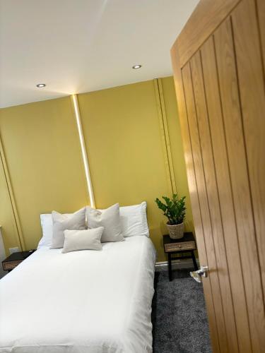 a bedroom with a bed with white pillows at Modern two bed apartment in Hull