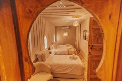 a bedroom with two beds and a mirror at Riad Aslal in Marrakech