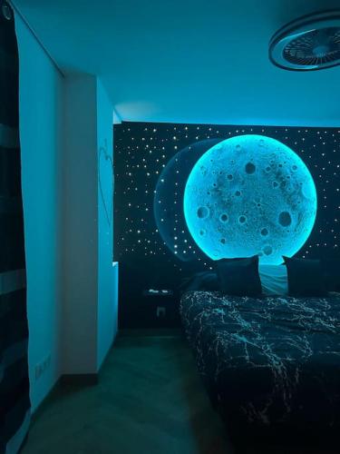 - une chambre avec une fresque murale sur la lune dans l'établissement Appartement vue Saône et Lune, à Mâcon