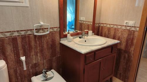 ein Badezimmer mit Waschbecken, Toilette und Spiegel in der Unterkunft Casa bonita els muntells in Els Muntells