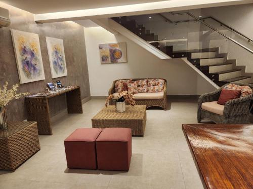 a living room with chairs and tables and stairs at Pousada Sol e Mar in Juquei