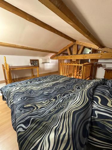 Cette chambre dispose d'un grand lit et de poutres apparentes. dans l'établissement Gîte des cerisiers, à Brue-Auriac