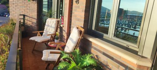 two chairs sitting on a balcony looking out of a window at Laredo Ocean Port in Laredo