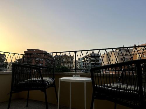 Dos sillas y una mesa en un balcón con vista. en Near Vatican, Irnerio 47 Guest House, en Roma